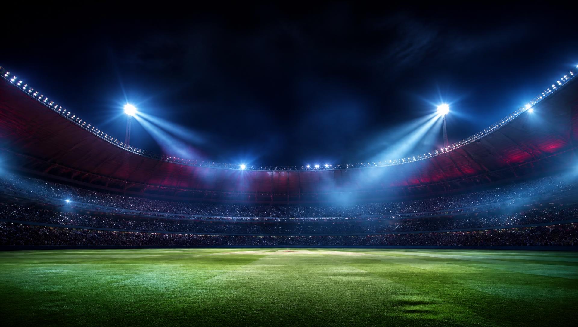 Floodlit cricket stadium at night